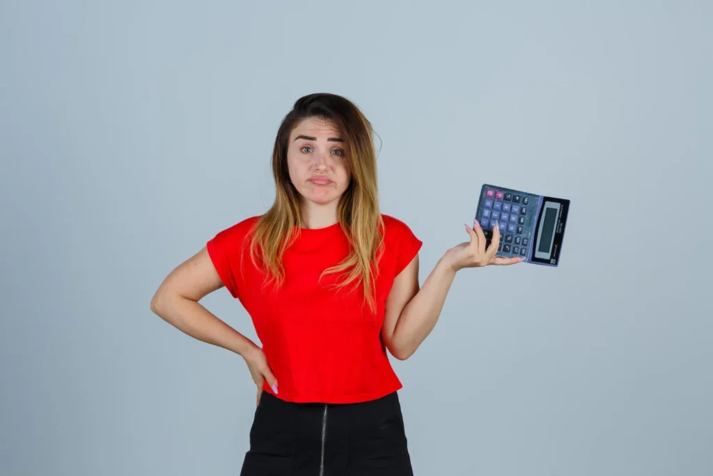 Femme perplexe tenant une calculatrice Femme perplexe tenant une calculatrice montrant les économies d'un abonnement IPTV pas cher comparé aux services de câble traditionnels